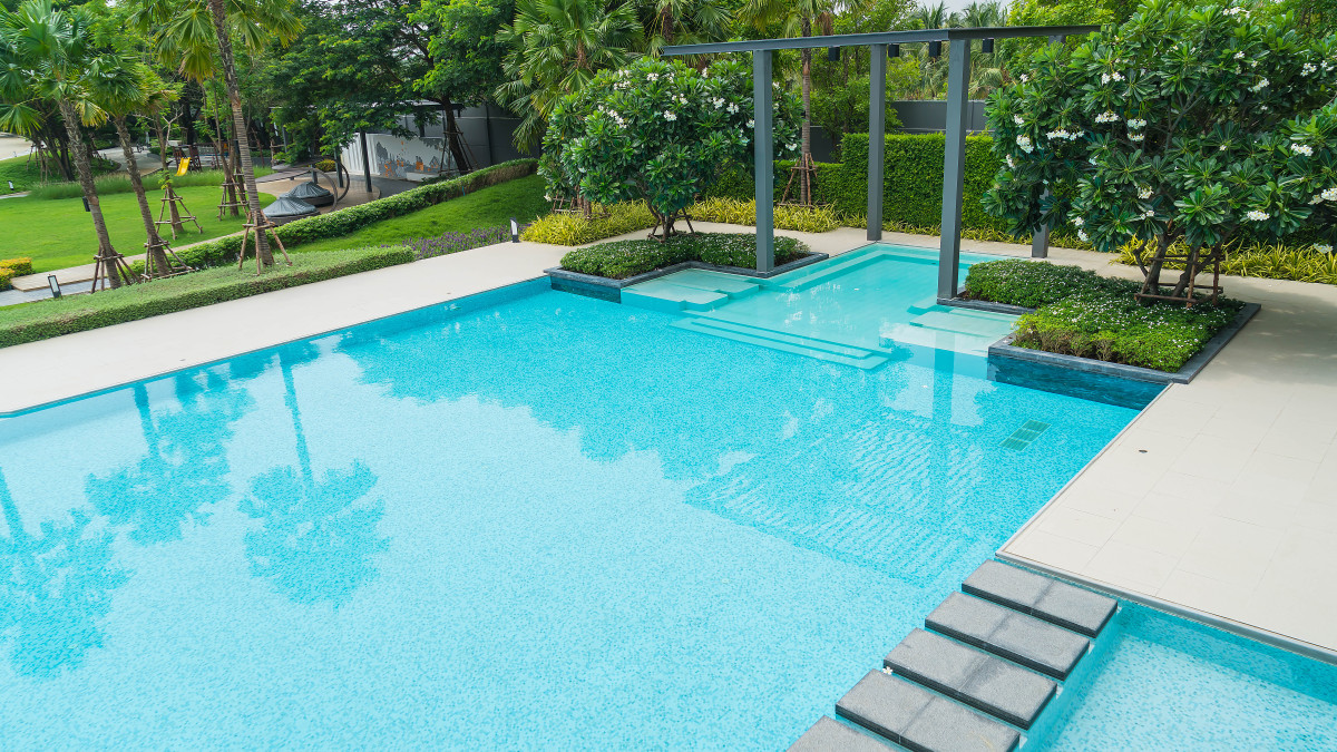 une jolie et grande piscine dans le jardin d'une villa